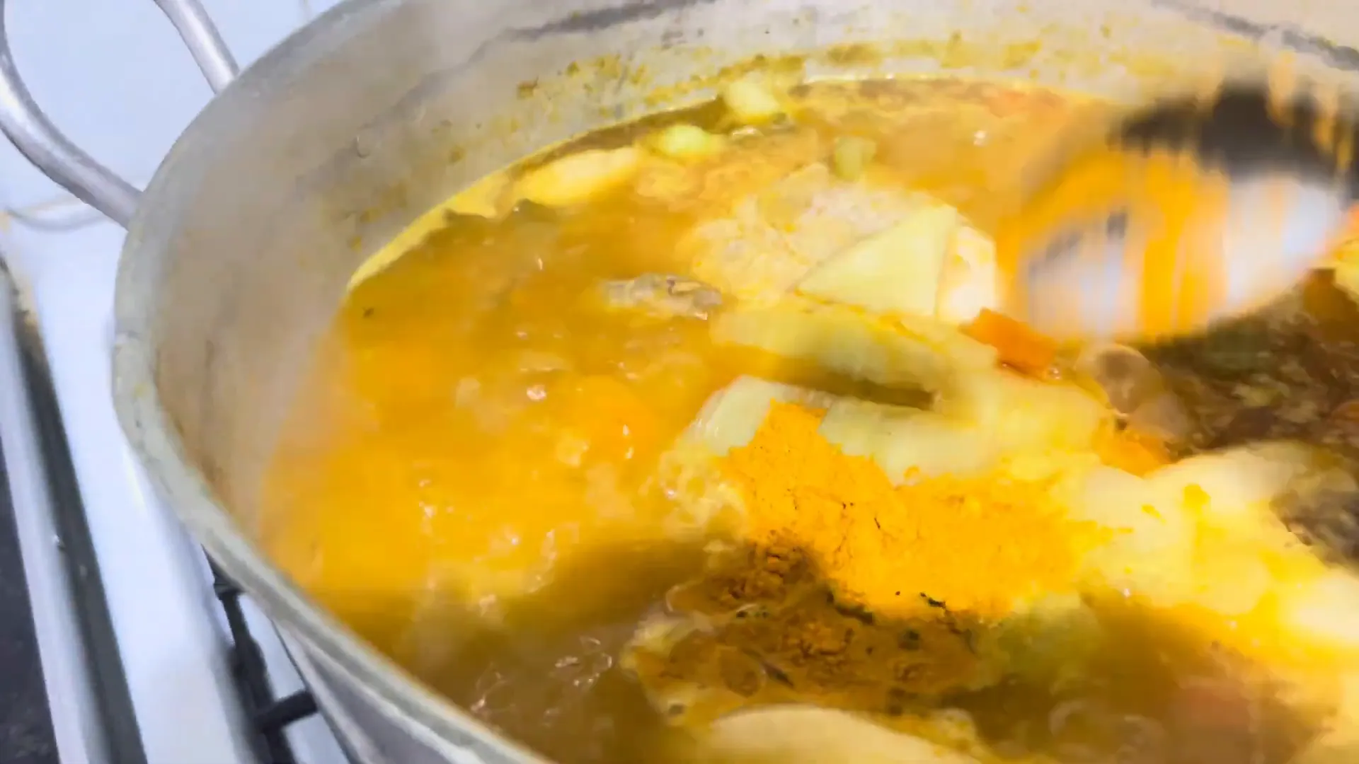 Adding spices to the chicken soup