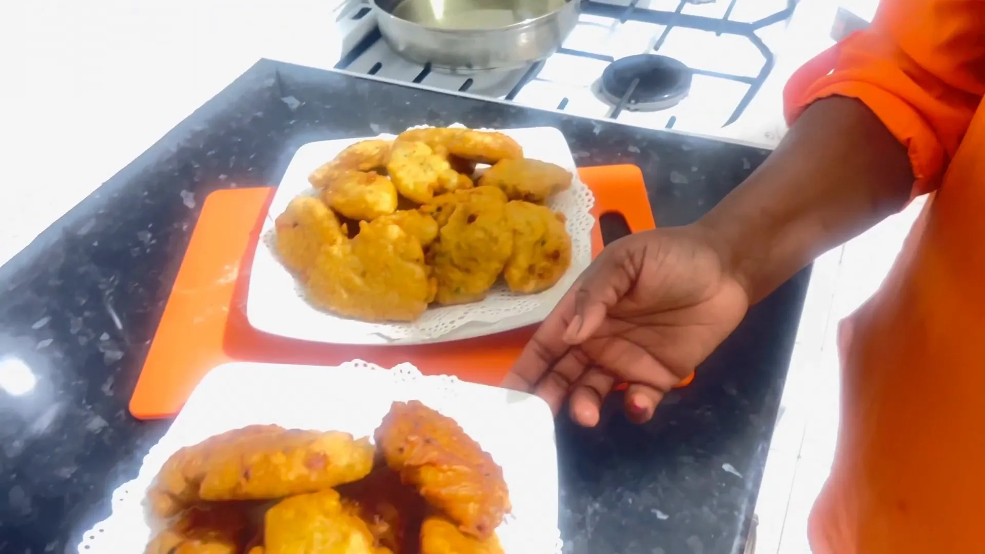 A close-up of golden brown saltfish fritters ready to be served with dipping sauce.