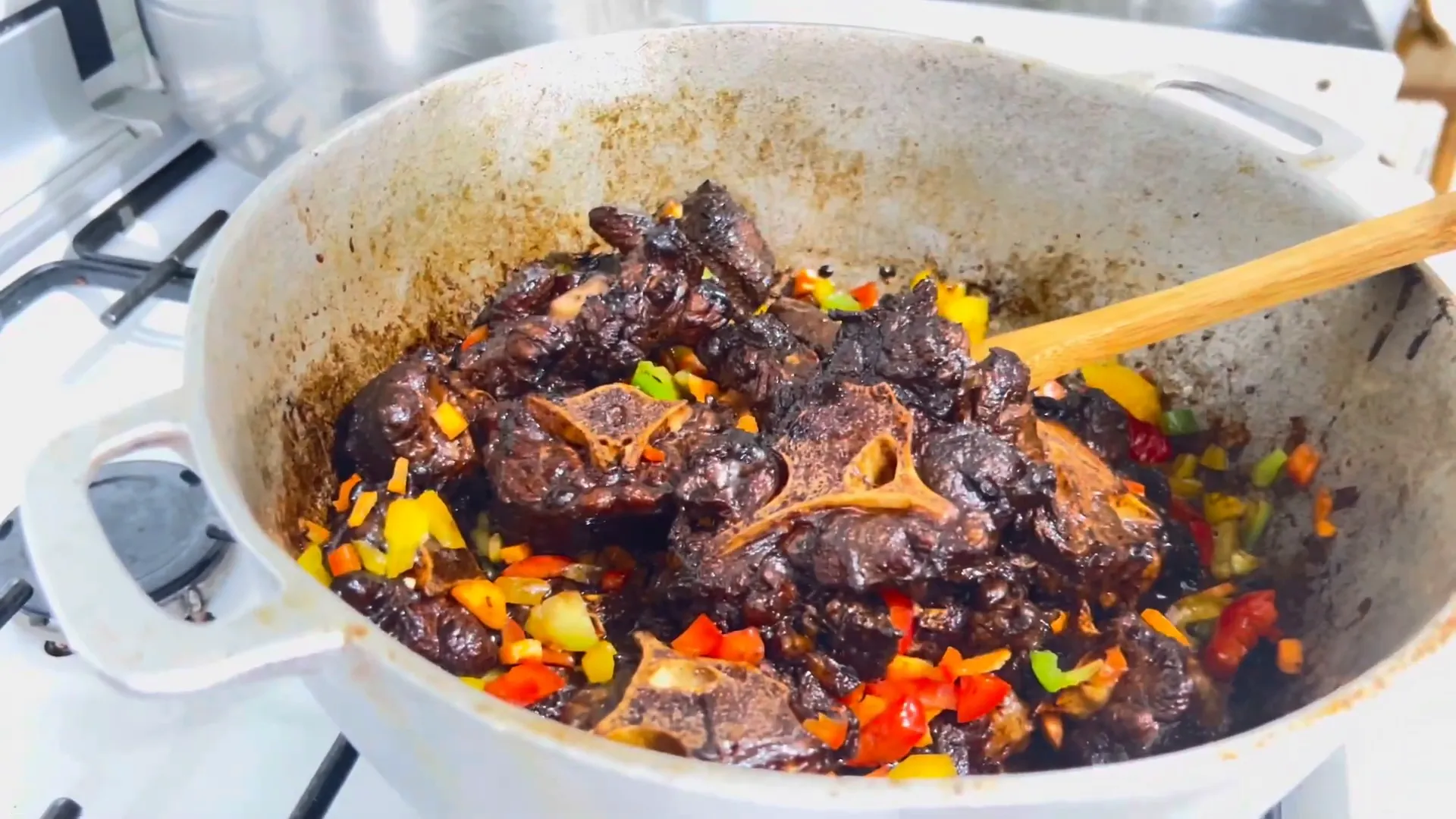 Adding boiling water to the sautéed oxtail and vegetables