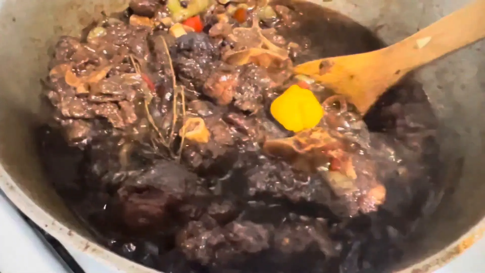 Adding butter beans to the simmering oxtail stew