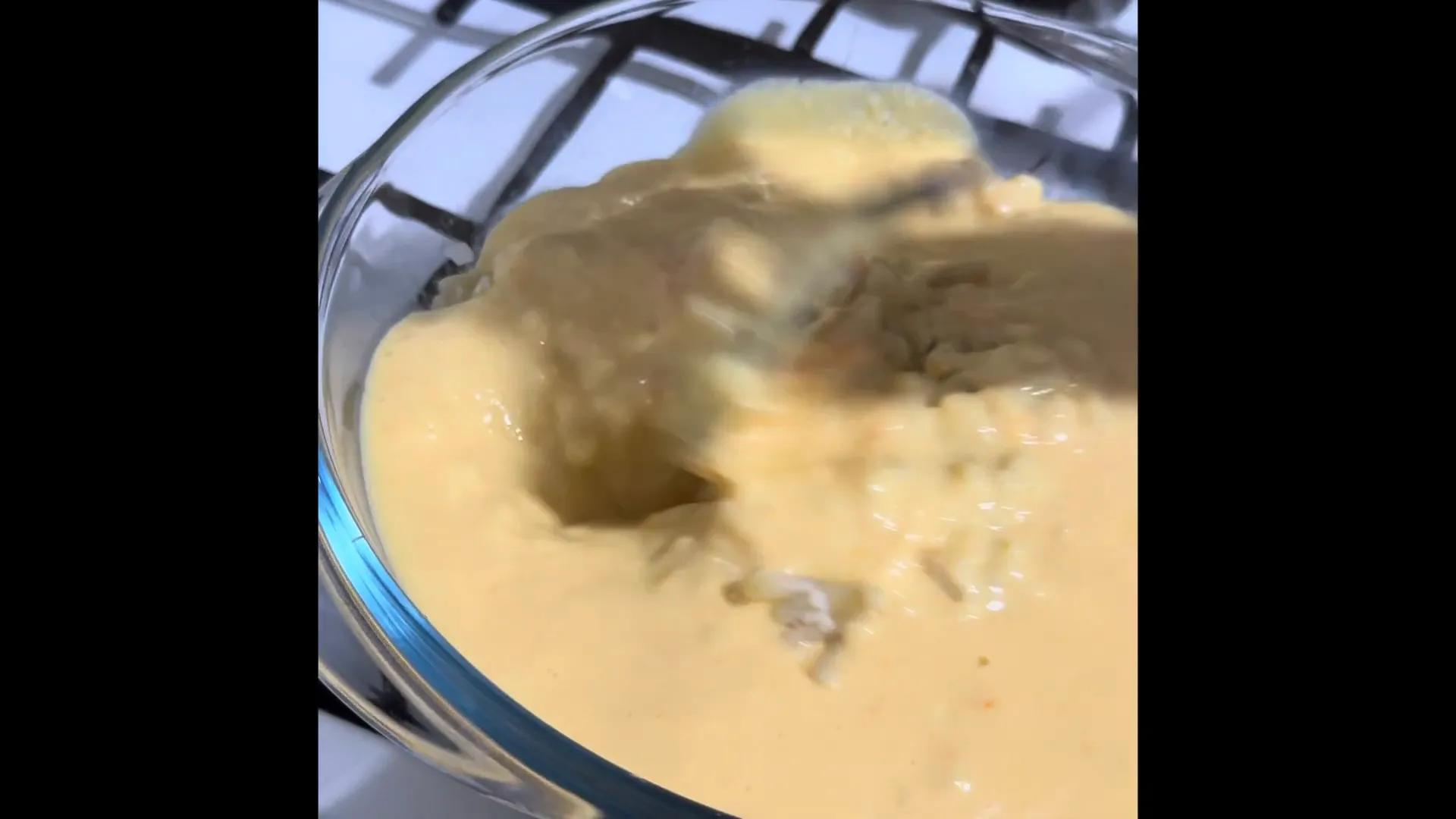 Pouring cheese sauce over macaroni