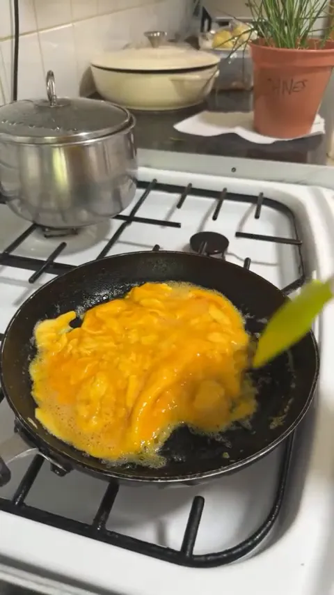 Soft and fluffy scrambled eggs cooking on low heat