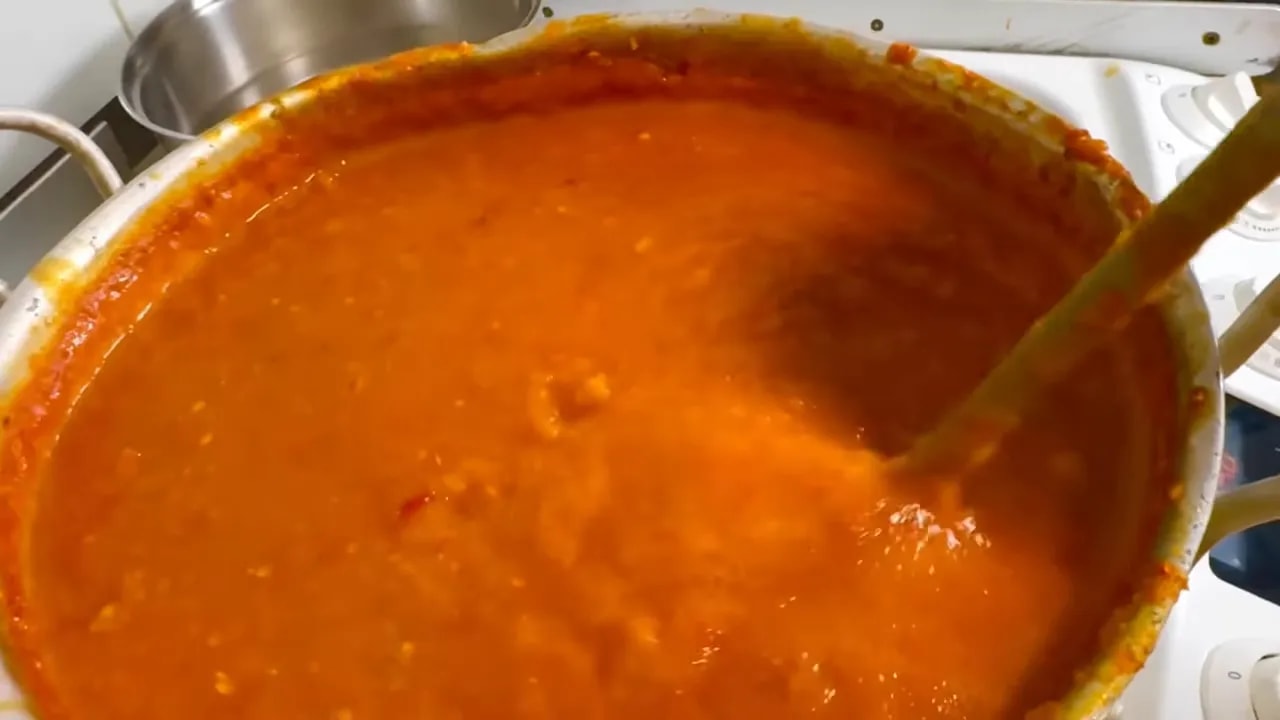 Jamaican-style habanero pepper sauce simmering in a pot before forming a skin